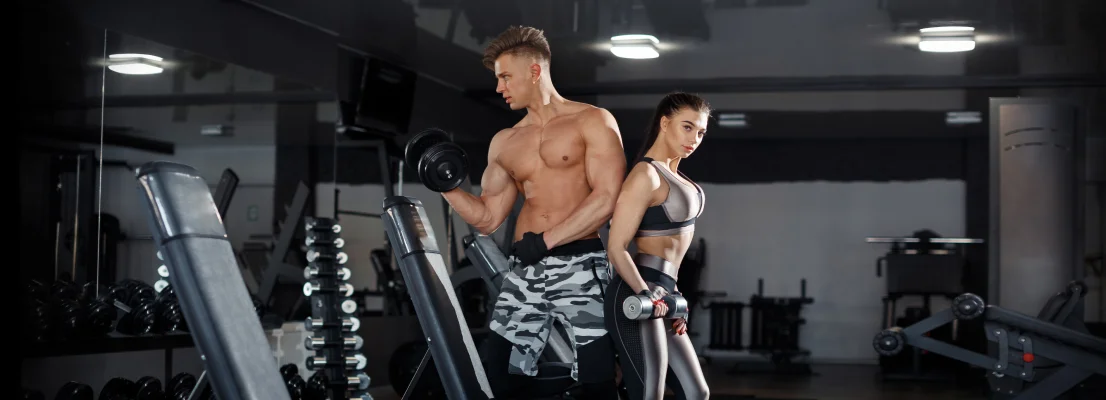 Fitness Woman and Man posing in Gym